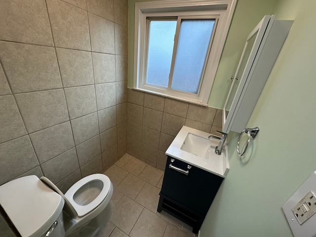 bathroom with tile patterned floors, toilet, tile walls, and vanity