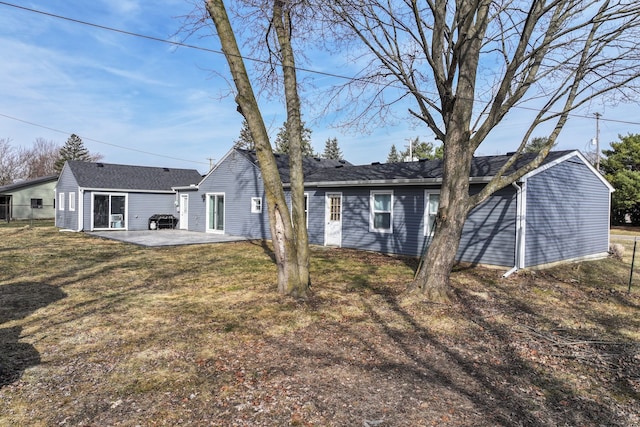 back of house with a patio and a lawn