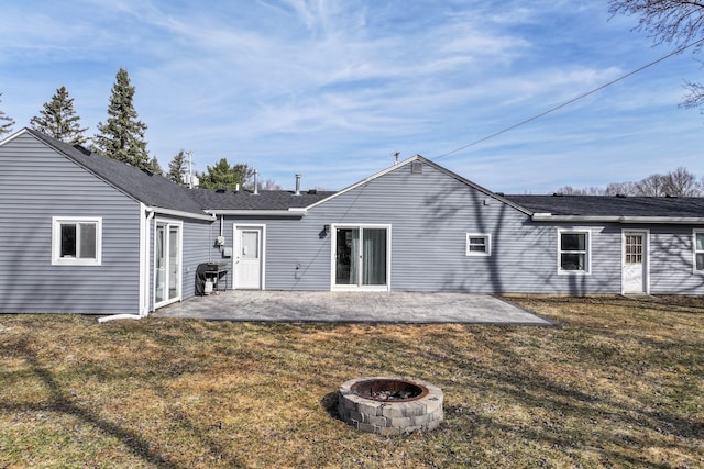 back of property with a patio, a lawn, and an outdoor fire pit