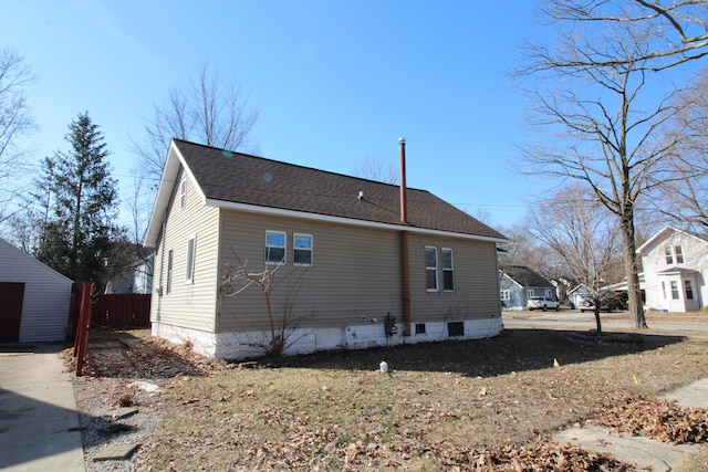 rear view of property featuring fence and a shingled roof