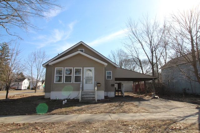 bungalow-style house featuring a carport, entry steps, and driveway