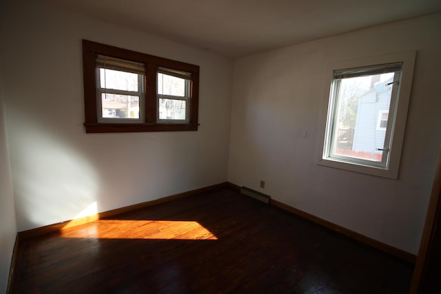 spare room with dark wood finished floors and baseboards