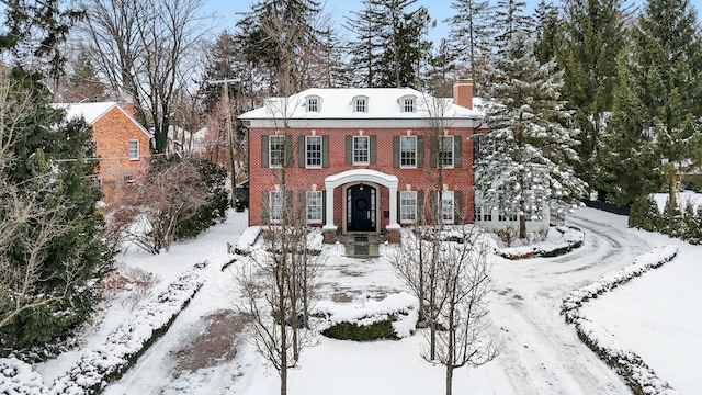 colonial home with brick siding and a chimney