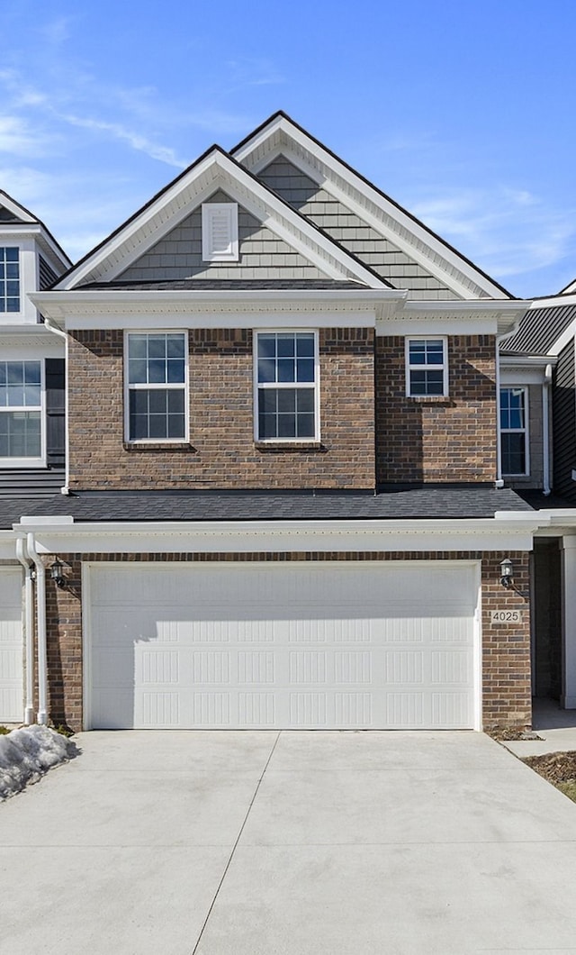 view of front of house featuring brick siding, an attached garage, and driveway