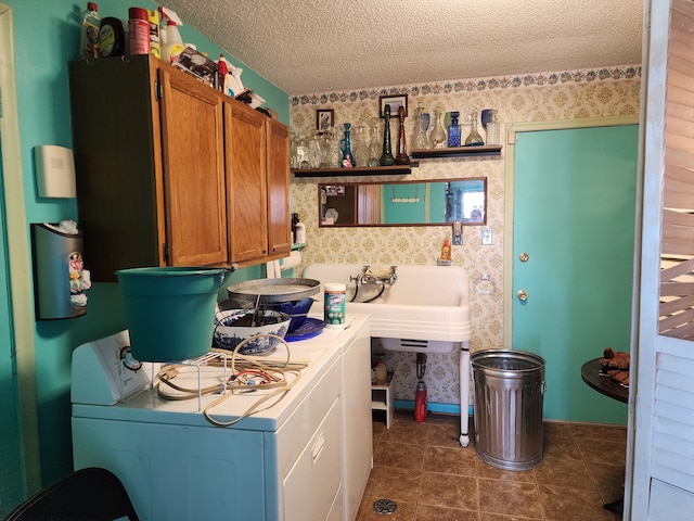 laundry room with washer and dryer, a textured ceiling, cabinet space, wallpapered walls, and baseboards