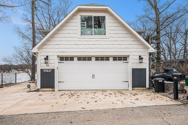 detached garage featuring fence