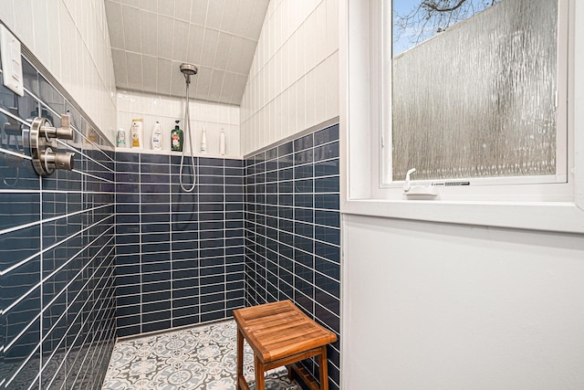 full bath featuring tiled shower and tile patterned flooring