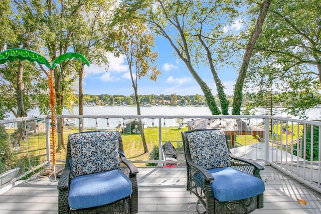 wooden terrace featuring a water view and a lawn