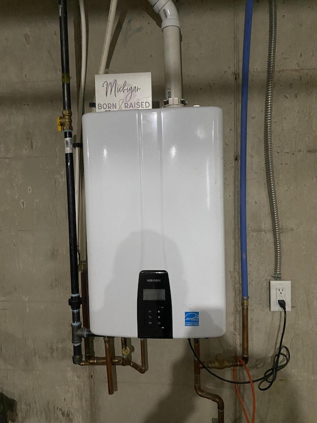 utility room featuring tankless water heater