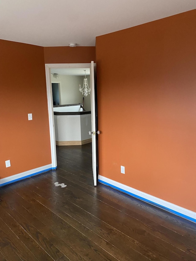 unfurnished room featuring baseboards and wood-type flooring