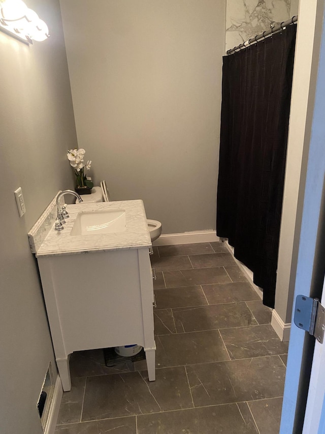 full bath with baseboards, toilet, and vanity