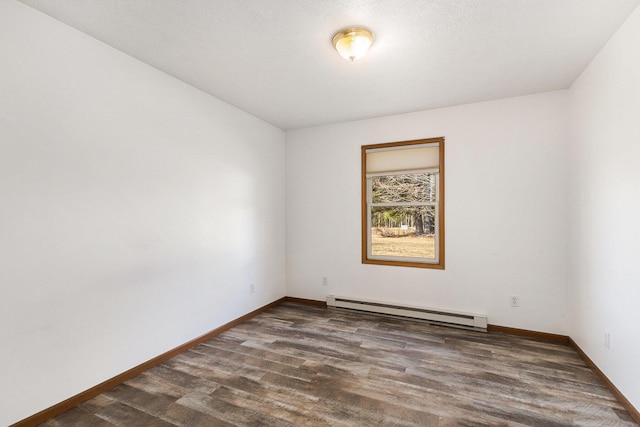 unfurnished room with a baseboard heating unit, baseboards, and dark wood-style flooring