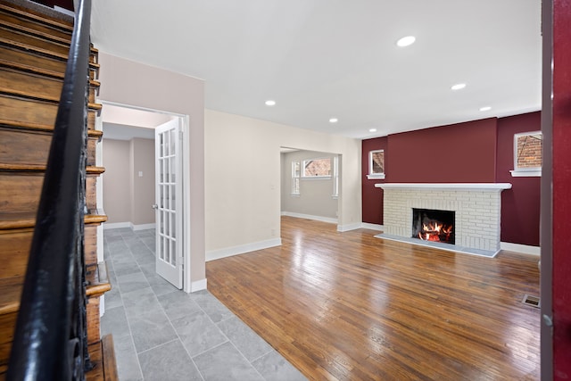 unfurnished living room featuring recessed lighting, baseboards, and a fireplace