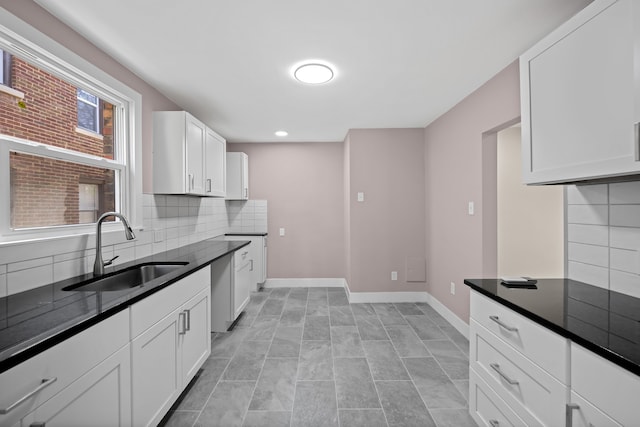 kitchen featuring decorative backsplash, baseboards, recessed lighting, white cabinetry, and a sink