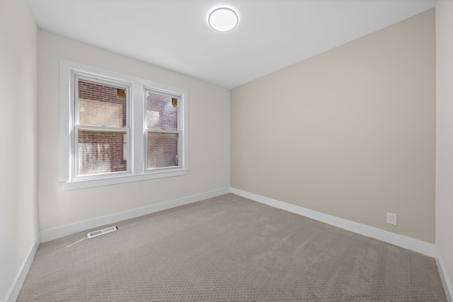 carpeted empty room featuring baseboards and visible vents