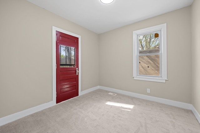empty room featuring baseboards, visible vents, and carpet