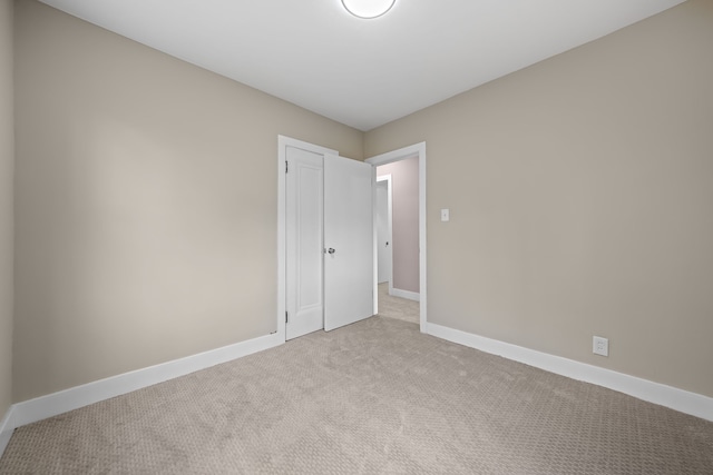 carpeted empty room featuring baseboards