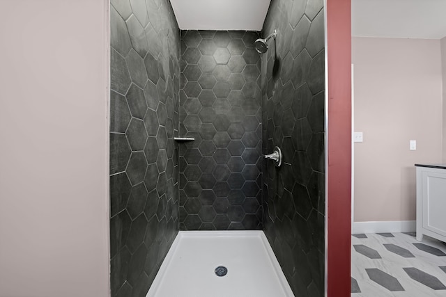 full bathroom with baseboards and tiled shower