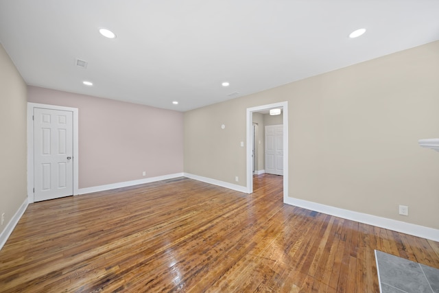empty room with baseboards, recessed lighting, and hardwood / wood-style floors