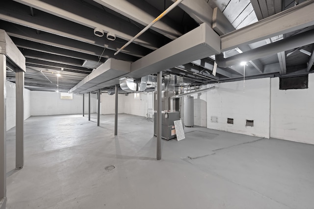 unfinished basement featuring heating unit and gas water heater