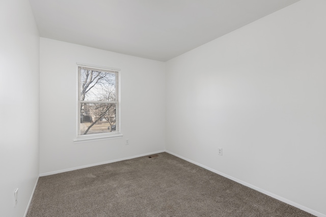 carpeted spare room featuring baseboards