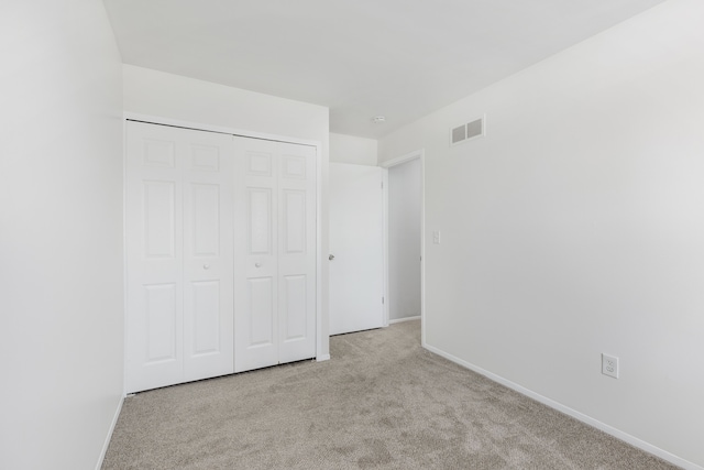 unfurnished bedroom featuring visible vents, baseboards, a closet, and carpet flooring