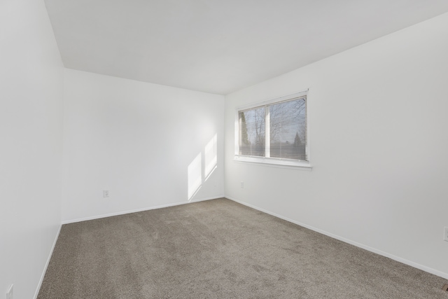 empty room featuring baseboards and carpet