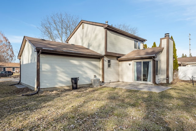 rear view of house featuring a patio area, central air condition unit, a lawn, and a chimney