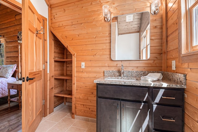 10924 E Grand Lake Rd, Presque Isle, MI 49777 - bathroom with vanity, wooden walls, vaulted ceiling, and tile patterned floors