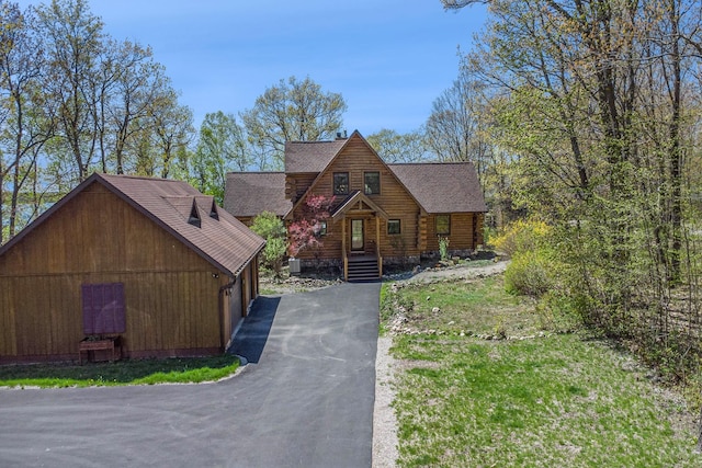 10924 E Grand Lake Rd, Presque Isle, MI 49777 - log cabin featuring asphalt driveway, a shingled roof, and log siding