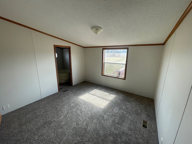 unfurnished bedroom featuring visible vents, carpet floors, a textured ceiling, and ornamental molding