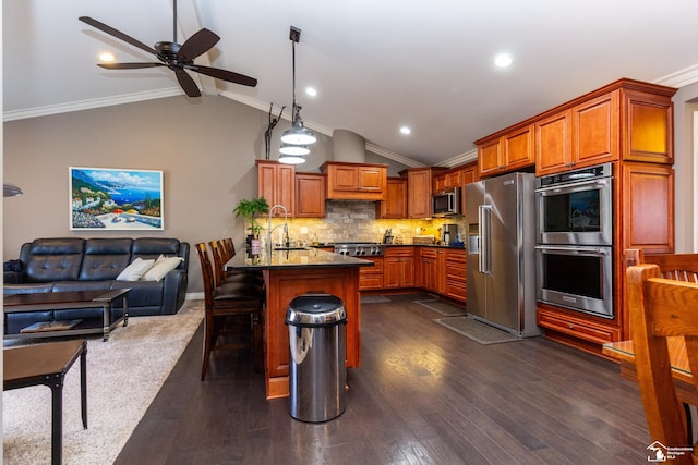 kitchen featuring a ceiling fan, vaulted ceiling with beams, appliances with stainless steel finishes, a kitchen bar, and open floor plan