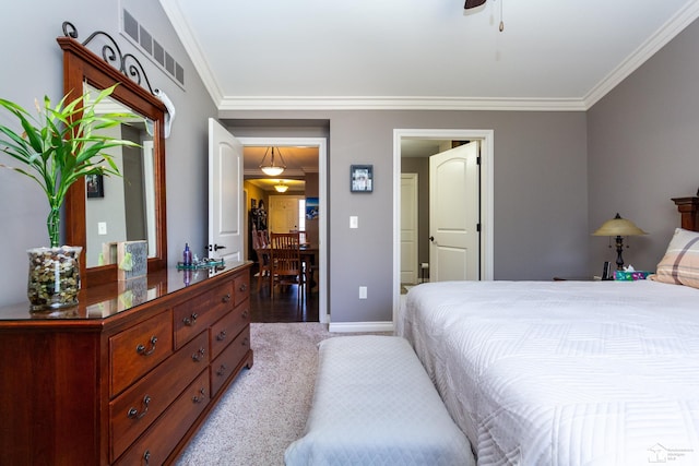 carpeted bedroom with visible vents, a ceiling fan, crown molding, and baseboards