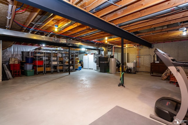 unfinished basement with gas water heater, freestanding refrigerator, and a sink