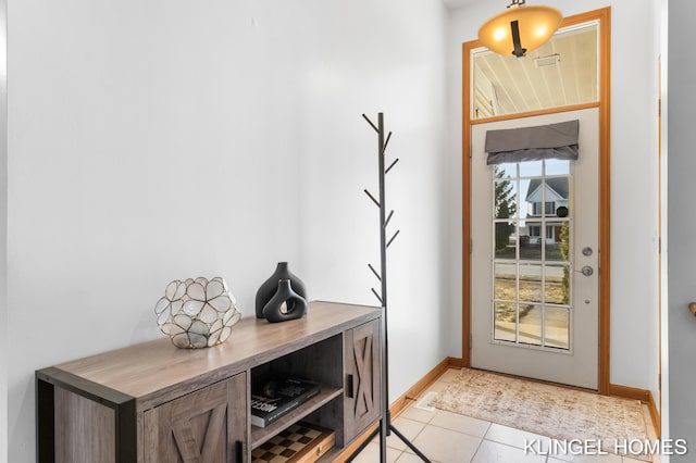 entryway with light tile patterned floors and baseboards