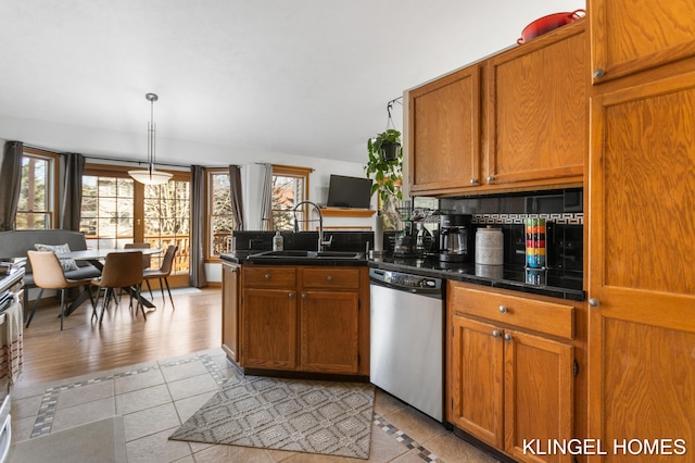 kitchen featuring dishwasher, brown cabinets, a peninsula, light tile patterned flooring, and a sink