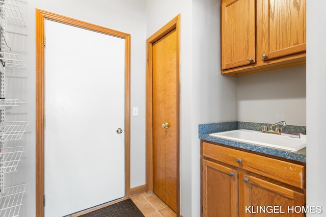 washroom featuring light tile patterned flooring and a sink