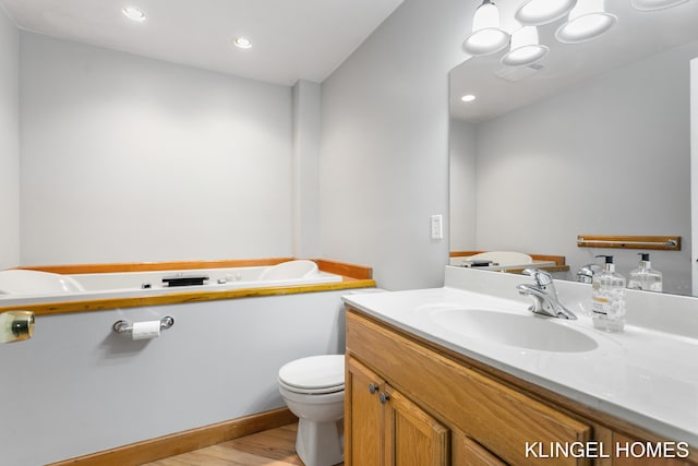 full bathroom featuring visible vents, a tub, toilet, wood finished floors, and vanity