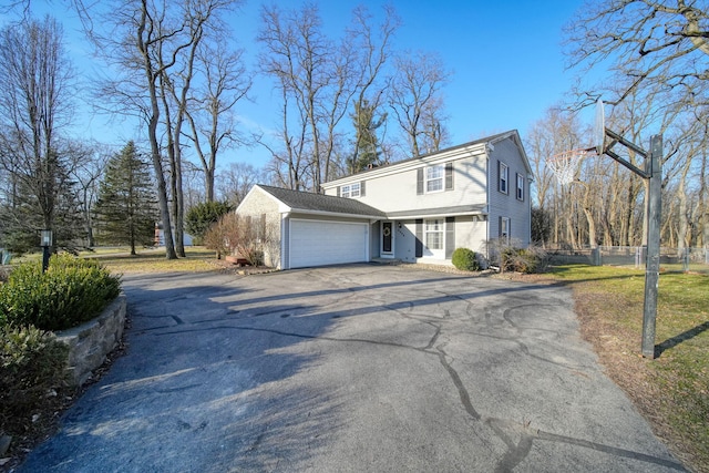 view of property exterior with fence, a garage, driveway, and a lawn