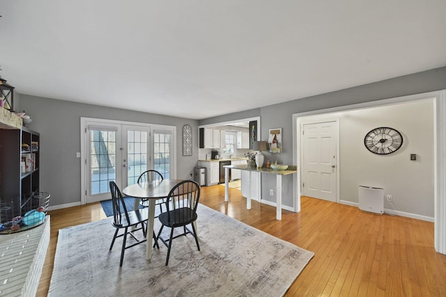 dining area with french doors, light wood-type flooring, and baseboards