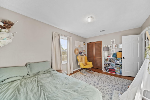 bedroom with a closet, baseboards, and wood finished floors