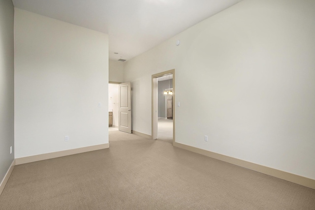 unfurnished room with light colored carpet and baseboards