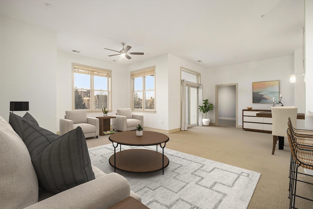 carpeted living area featuring visible vents, baseboards, and a ceiling fan