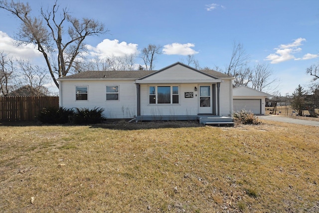 view of front of house featuring an outdoor structure, a front lawn, a garage, and fence