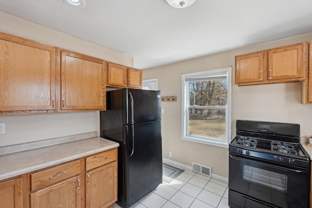 kitchen featuring visible vents, baseboards, light countertops, light tile patterned flooring, and black appliances