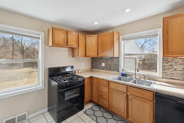 kitchen featuring black appliances, plenty of natural light, visible vents, and a sink