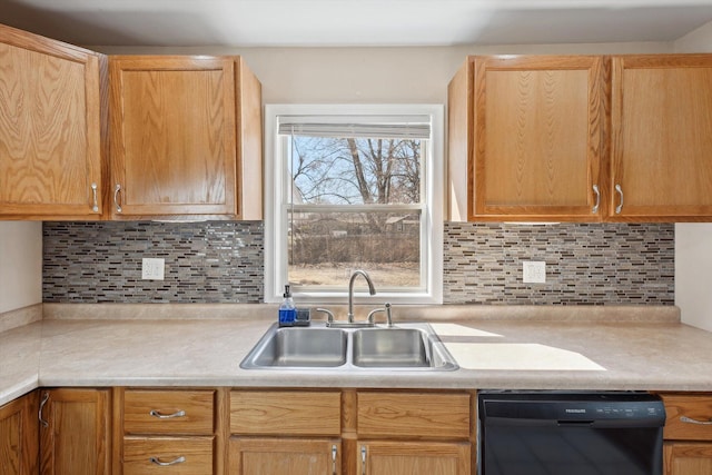 kitchen with light countertops, black dishwasher, tasteful backsplash, and a sink