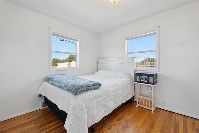 bedroom featuring visible vents, wood finished floors, and baseboards