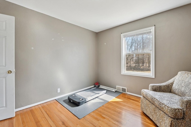 sitting room featuring visible vents, baseboards, and wood finished floors