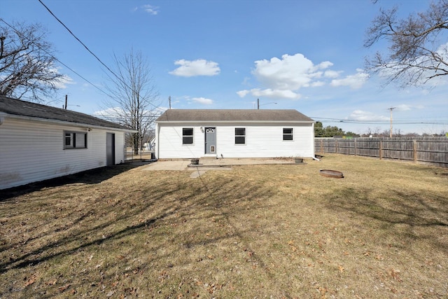 rear view of house featuring a lawn, a patio, and fence